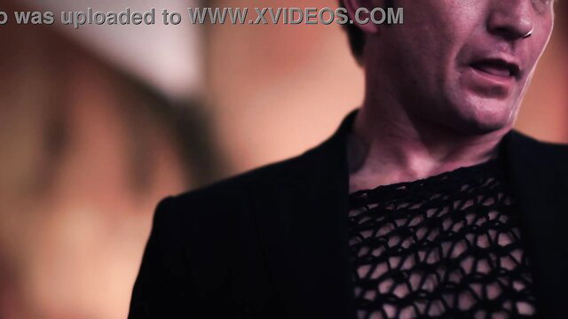 Mature MILF in sheer black mesh top smirks seductively closeup