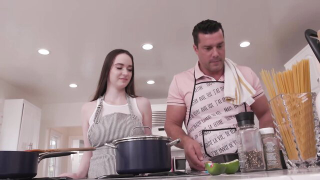 Stepsis in apron and lingerie cooks with stepbro in kitchen