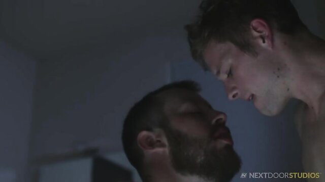 Ty Thomas kissing bearded hunk in dim light Next Door Studios
