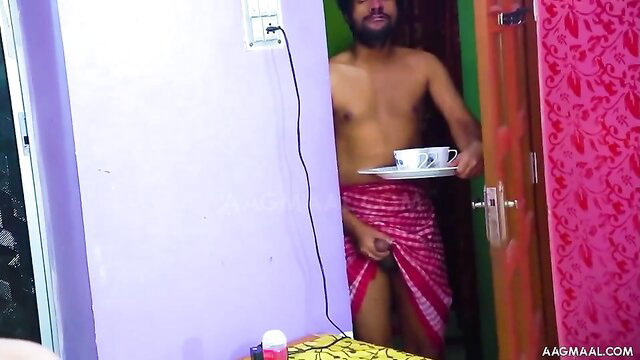 Naked Indian man in lungi holding tea cup at bedroom door