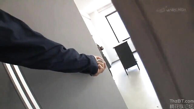 Man in dark suit opening door in JAV office scene