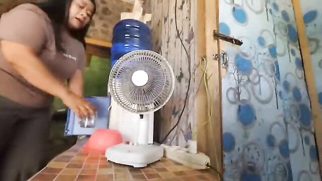 Chubby Asian MILF pouring water in tight tank top and pants