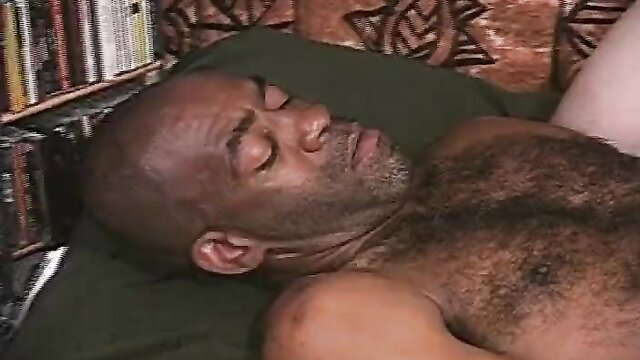 Bald black mature man with hairy chest sleeping nude on bed