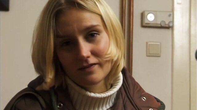 Young blonde in turtleneck and jacket at door, amateur pickup tease
