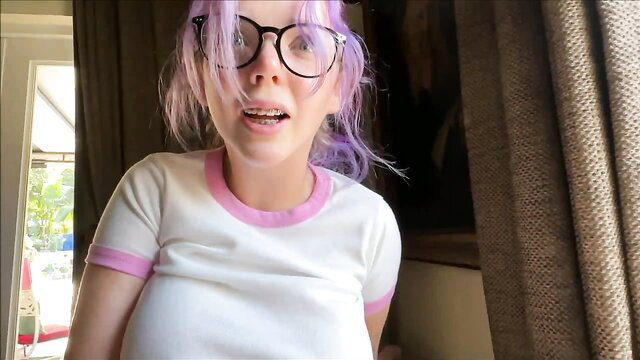 Purple-haired Alex Adams in tight pink-trim top, teasing expression