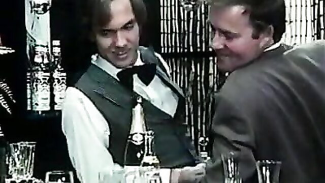 Disco Desire retro porn: Bartender in vest chats with suited man at bar