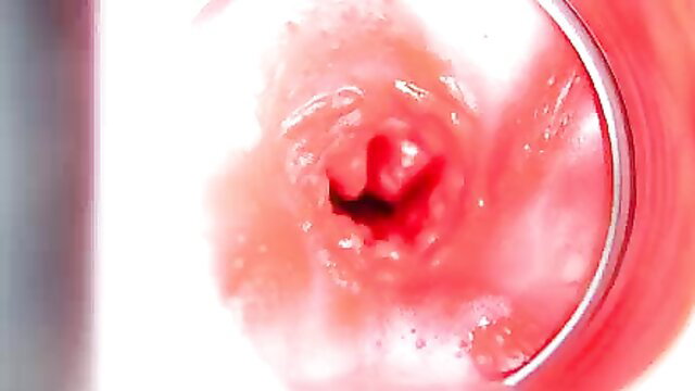 Close-up camera inside wet pink pussy with red ring speculum, 4K internal cumshot view