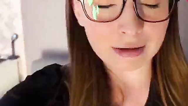 Closeup of beautiful brunette girl's face with glasses in hot amateur home sex