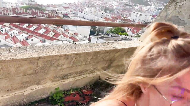 Blonde hottie with ponytail on rooftop overlooking city, teasing blowjob view