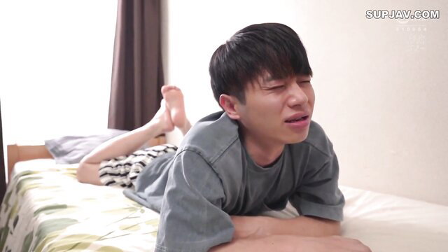 Asian twink guy lying on bed in grey shirt and shorts, JAV uncensored tease