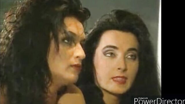 Two glamorous brunettes with heavy makeup in close seductive pose
