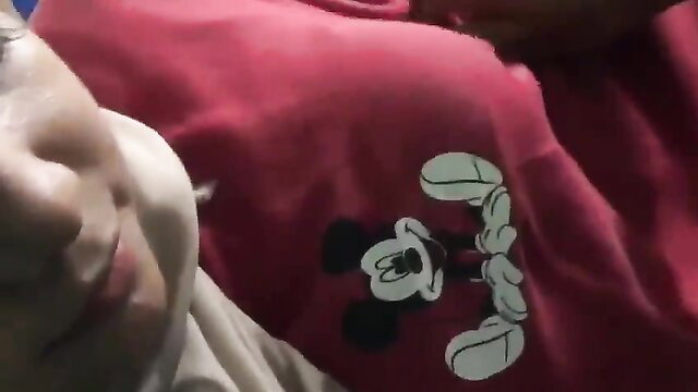Asian woman in pink Mickey Mouse hoodie smiling teasingly close-up