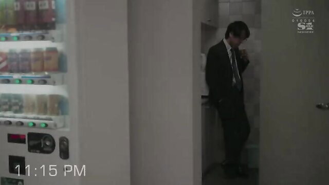 Middle-aged suited boss at vending machine in JAV office harassment scene