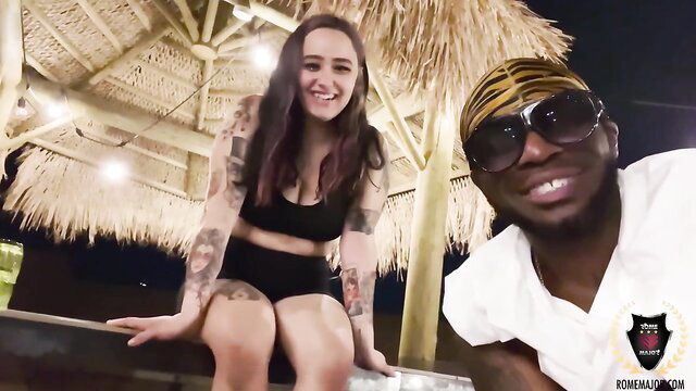 Tattooed brunette babe with black dude in beachwear selfie smile