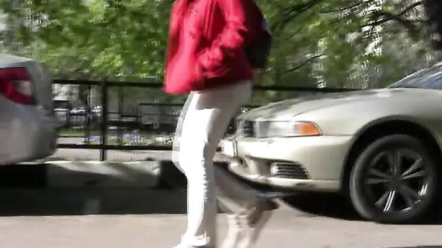 Brunette skanky city girl in tight white pants near cars outdoors