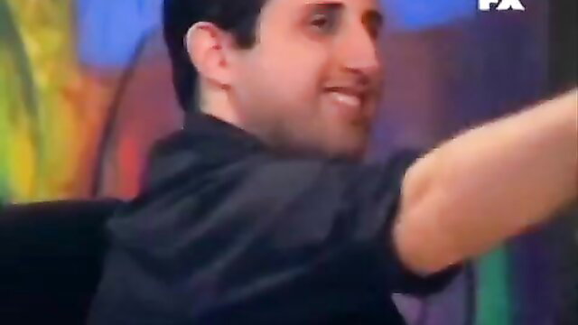 Smirking Middle Eastern guy gesturing on colorful candid adult TV set