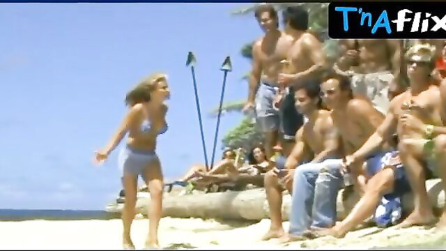 Pamela Anderson in skimpy blue bikini on beach with hunks in Baywatch