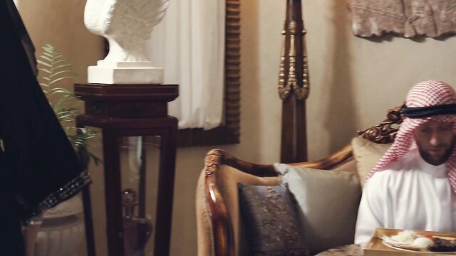 Nadia Ali in hijab and abaya in luxurious Middle Eastern bedroom