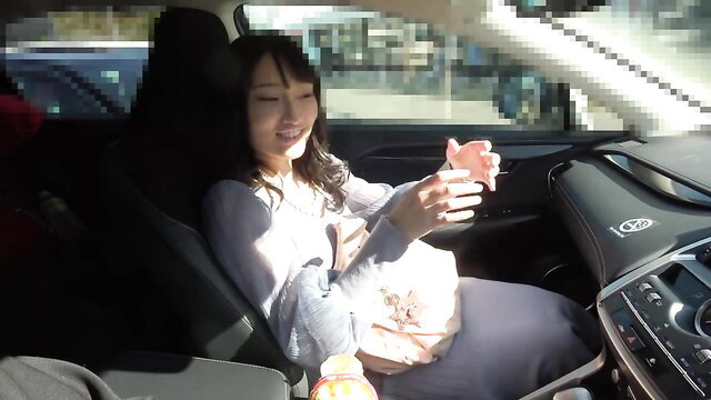 Sumire Niwa smiling in car holding phone, teasing car sex challenge