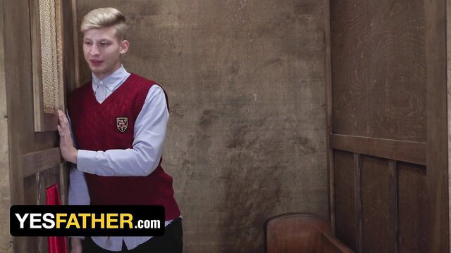 Blond altar boy in school uniform leans in confessional booth