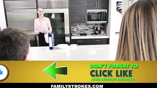 Blonde stepmom in pink dress holds folder as stepbro and girlfriend watch in kitchen