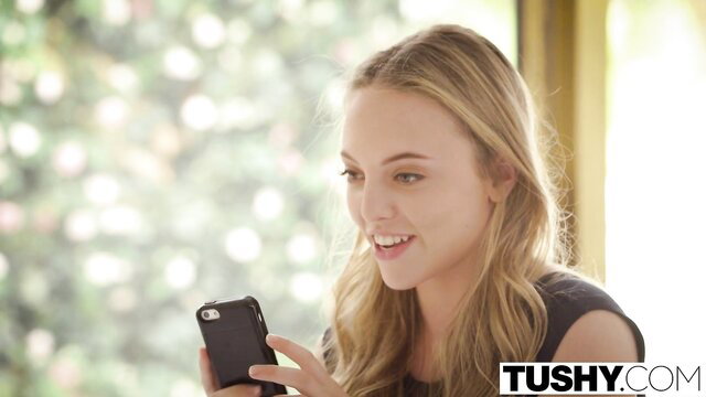 Blonde Cassidy Klein smiling on phone in Tushy anal scene