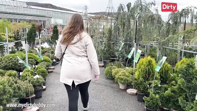Gorgeous babe in beige coat and leggings walking in garden center