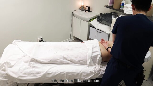 White MILF winces as Asian masseur rubs her sore bare ass in massage