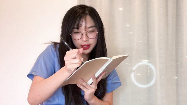 Elle Lee as sexy Asian intern in glasses writing, blue scrubs