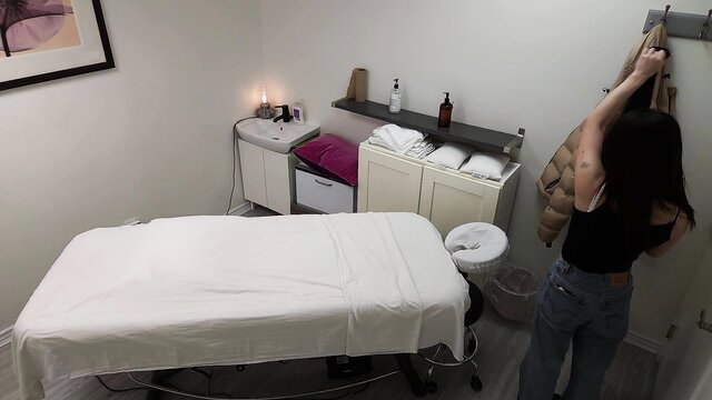 Shy Japanese girl with perfect body hangs clothes before special massage