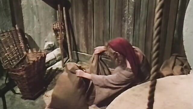 Redhead medieval wench in robe grabs sack in 1985 classic porn