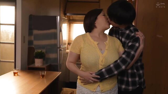Asian couple kissing passionately in kitchen, yellow cardigan wife and plaid shirt hubby