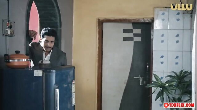 Indian man in suit gesturing in kitchen, Ullu adult scene