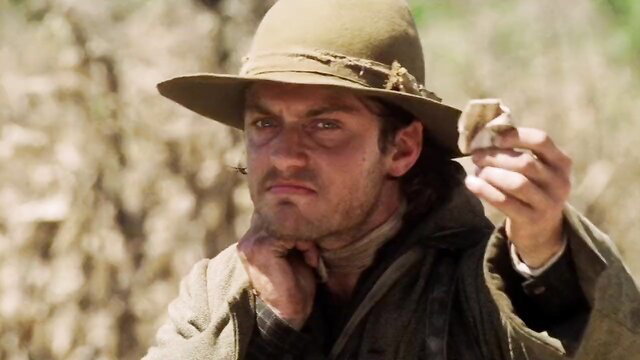 Rugged cowboy in hat holds bone in Cold Mountain 2003 scene