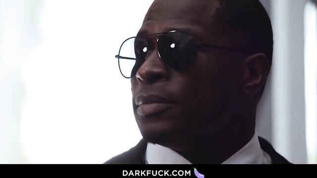 Black security officer Rob Piper in shades stares intensely