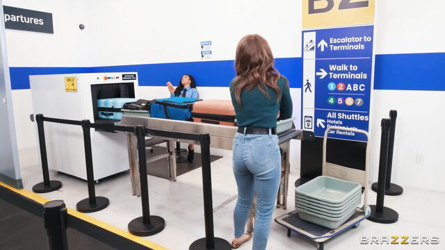 Tattooed athlete behind curvy brunette security agent at airport scanner