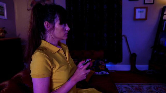 Sydney Harwin in tight yellow polo shirt, ponytail, gaming with controller
