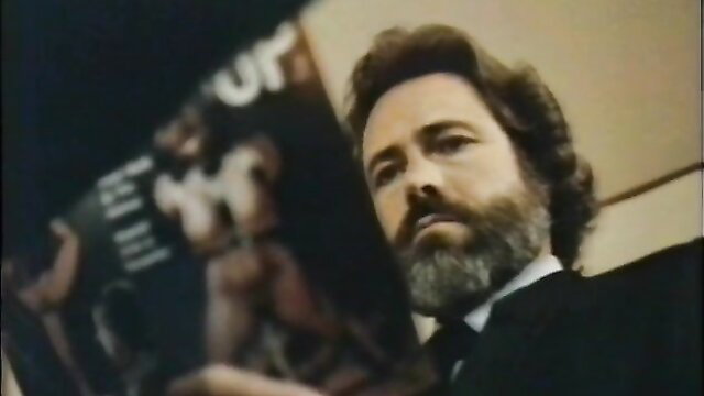Bearded man in suit examines vintage porn mag with nude hunk, Golden Girls 1983
