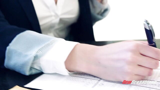 Businesswoman in blouse and suit writing at desk closeup