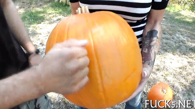 Tattooed couple fingering huge pumpkin outdoors erotic fun