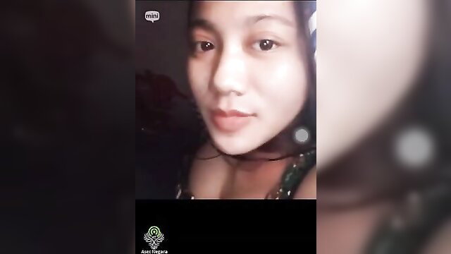 Closeup of cute Asian girl Nabila smiling in low-light amateur video call