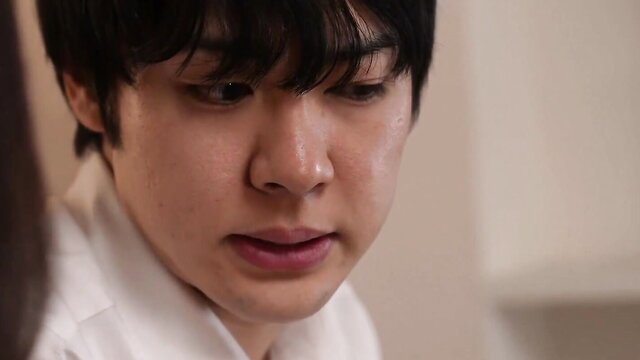 Close-up of young East Asian man's intense gaze in JAV scene