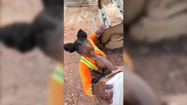Black babe in orange hi-vis groping white guy cock at construction site
