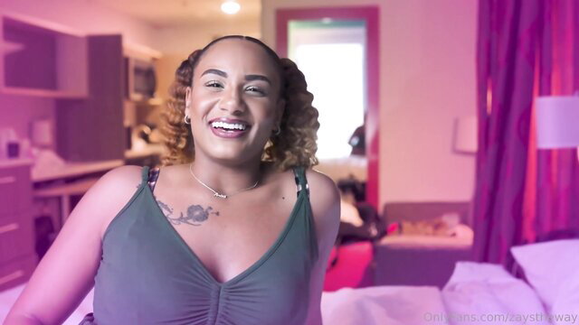 Smiling black woman with curly hair in cleavage-baring tank top