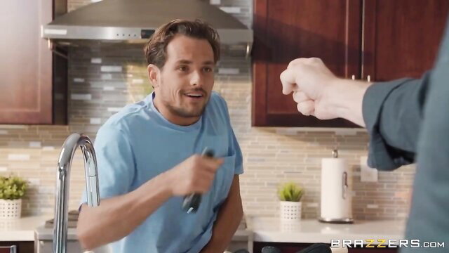 Fit plumber smiles holding spatula as man fists him in kitchen