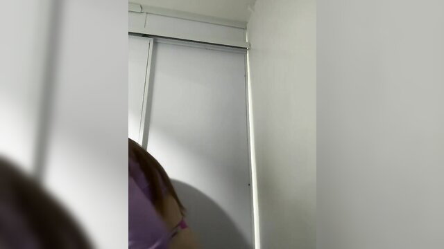 Amateur girl in purple top by white closet door public webcam tease
