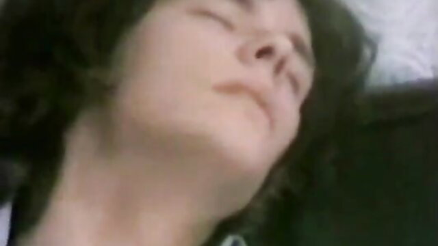 Closeup of brunette beauty with full lips lying back in classic anal XXX scene