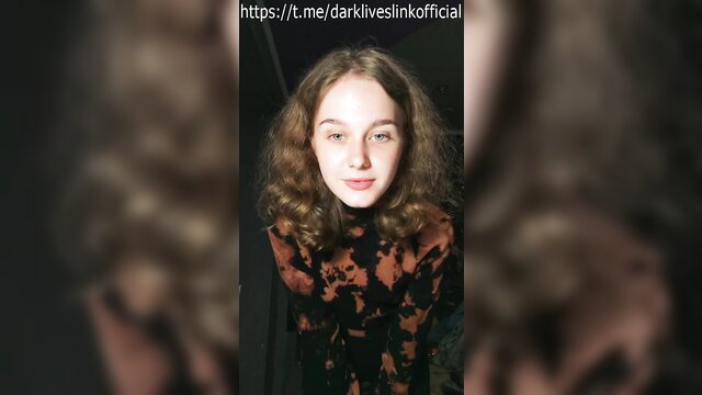 Cute wavy-haired brunette teen in batik top smiles closeup