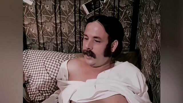 Janine mature man with mustache lounging shirtless in bed