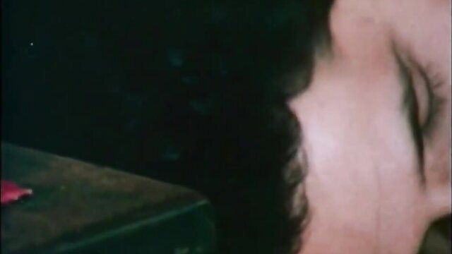 Closeup of seductive woman's face with dark hair in 1981 adult film Lips